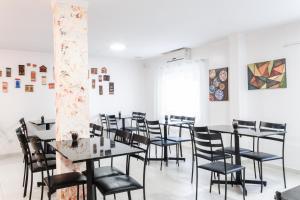 a room with tables and chairs and paintings on the wall at Mar e Mar Florianópolis in Florianópolis