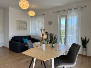 a living room with a wooden table and chairs at Guest House KovacevicA in Hvar