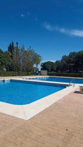een groot zwembad met een blauwe lucht op de achtergrond bij Bonito y moderno estudio con vistas al mar in Benalmádena