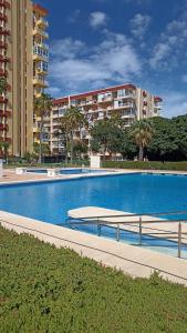 een groot zwembad met gebouwen op de achtergrond bij Bonito y moderno estudio con vistas al mar in Benalmádena