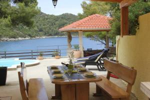 een tafel en stoelen op een patio met uitzicht op het water bij House Anna in Sobra