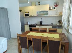 een keuken met een houten tafel en stoelen in een kamer bij House Anna in Sobra