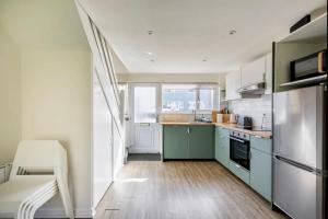 a kitchen with green cabinets and a white refrigerator at Peaceful stay 5 mins to beach and coast path walks in Pembrokeshire