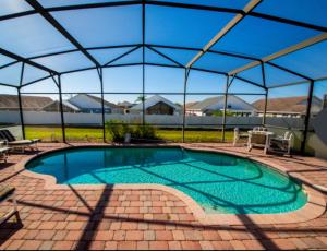 a swimming pool in a tent with chairs and a table at Orlando Vacation Villa in Orlando