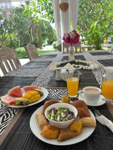 una mesa con platos de comida y bebidas. en WHITE Nyumba, en Malindi