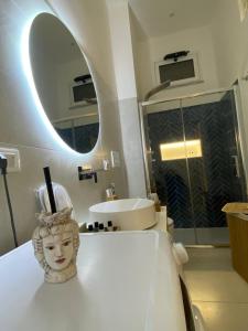 un bagno con una statua su un bancone con specchio di Casa Don Saro a Giardini Naxos