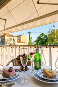 una mesa con dos copas de vino y un trozo de tarta en Apartment Lauma, en Zadar