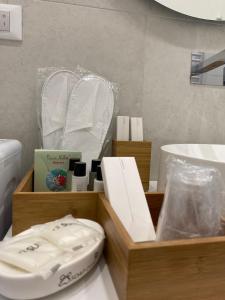 een houten doos met handdoeken en een wastafel in de badkamer bij Casa Don Saro in Giardini Naxos