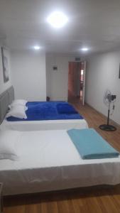 a bedroom with a large bed and a fan at HOTEL JIMENA in Iquique