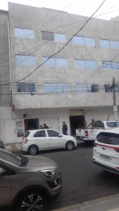 HOTEL JIMENA في إكيكي: مجموعة سيارات متوقفة أمام مبنى