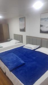 1 dormitorio con 2 camas y sábanas azules en HOTEL JIMENA, en Iquique