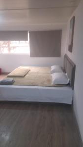 a large bed in a room with a large window at HOTEL JIMENA in Iquique