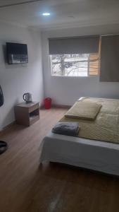 Un dormitorio con una cama grande y una ventana en HOTEL JIMENA, en Iquique