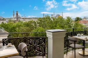 a balcony with tables and chairs and a view of a city at Rast Hotel Sultanahmet in Istanbul