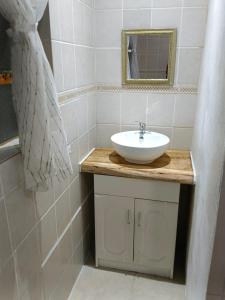 uma casa de banho com um lavatório e um espelho em Guest Lodge on the Edge em Stormsrivier
