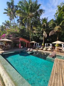 uma piscina com cadeiras e guarda-sóis num resort em Pousada e Mergulho Jamanta em Angra dos Reis