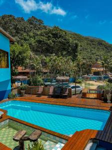 a swimming pool with a mountain in the background at Hotel Garni Cruzeiro do Sul in Paraty