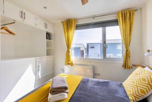 Un dormitorio con una cama amarilla y una ventana en Beach Woods Coastal Path chalet en Pembrokeshire
