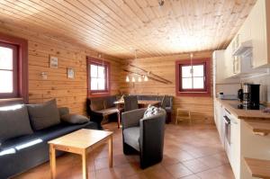 a living room with a couch and a table at Gemütliches neu erbautes Blockhaus auf Berghof mit Sauna und Kamin in Galåbodarna