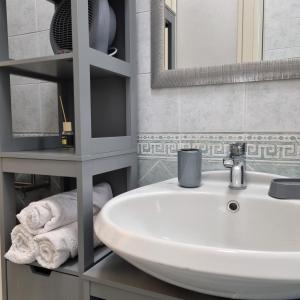 uma casa de banho com lavatório, espelho e toalhas em La Casetta di Oppi em Nápoles