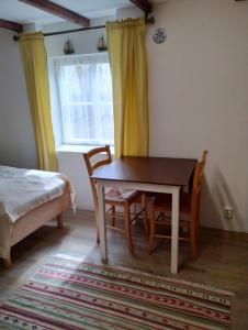een slaapkamer met een tafel en 2 stoelen en een raam bij Saunallinen huone omakotitalossa - old wood house - in Turku