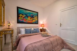 a bedroom with a bed with a painting on the wall at Casa mare & spa Alghero in Alghero