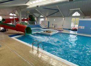 a large swimming pool with a slide in it at Sea View, Thorness Bay in Porchfield