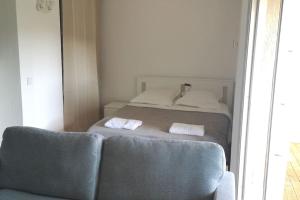 een slaapkamer met een bed met 2 kussens en een bank bij Terrasse ensoleillée et accès à la piscine vue mer in Vallauris