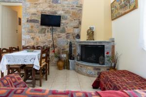 Plátsa的住宿－Platsa Theasis，客厅配有桌子和石头壁炉