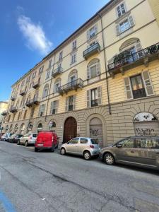 een rij auto's geparkeerd voor een gebouw bij Centralissimo appartamento su due livelli "2" in Turijn