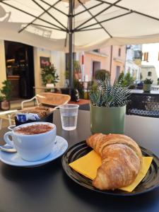 una mesa con un plato de pan y una taza de café en B&B la Quiete, en Leverano