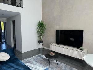 a living room with a blue couch and a flat screen tv at Cukura Loft in Jelgava