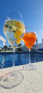 two wine glasses sitting on a table next to a pool at MEERBLICK DUPLEX POOL-VILLA REGIRMA DELUXE bis 8 Personen in Vodice