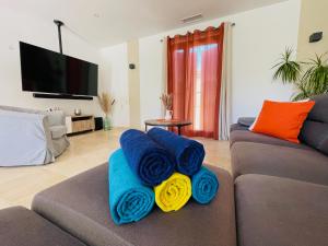 - un salon avec des serviettes bleues et jaunes sur un canapé dans l'établissement Gite La Madeleine du Luberon., à Lioux