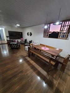 ein Wohnzimmer mit einem Holztisch und Stühlen in der Unterkunft Casa em São Lourenço in São Lourenço