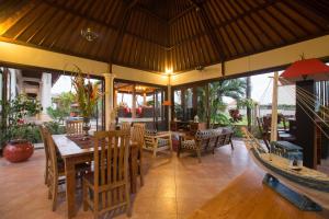 a dining room with a table and chairs and a boat at Villa Padi in Canggu