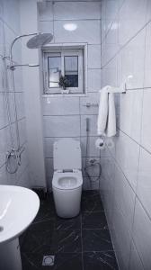 een witte badkamer met een toilet en een wastafel bij Dreams hotel in Douala