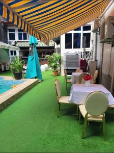 eine Terrasse mit einem Tisch und Stühlen auf grünem Gras in der Unterkunft Dreams hotel in Douala