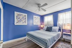 a blue bedroom with a bed and a ceiling fan at Little Pineapple Cottage in St Petersburg