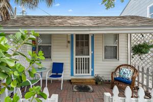 ein Haus mit zwei Stühlen und einem Tisch auf einer Terrasse in der Unterkunft Little Pineapple Cottage in St Petersburg + 12 Fotos