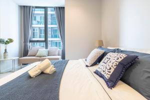 a bedroom with a large bed with pillows on it at Hyde Sukhumvit 11 Branded Suites in Bangkok