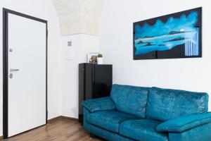 ein blaues Sofa im Wohnzimmer mit Spiegel in der Unterkunft La Pala Suite Apartment in Leporano