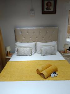 uma cama com um cobertor amarelo e duas almofadas em Guest Lodge on the Edge em Stormsrivier