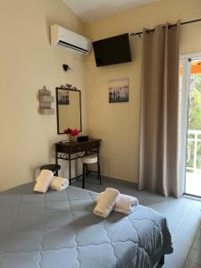a bedroom with a bed with a desk and a television at Studio Vasilis in Ýpsos