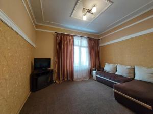 ein Hotelzimmer mit einem Sofa und einem Fenster in der Unterkunft Двокімнатні апартаменти у центрі in Luzk