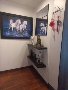 a room with three shelves with statues of horses on the wall at Departamento con jacuzzi 5 piso Condado 2 habitaciones in Quito