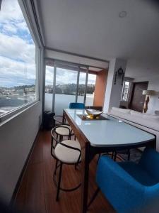 a room with a table and chairs and a large window at Departamento con jacuzzi 5 piso Condado 2 habitaciones in Quito