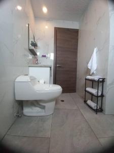 a white bathroom with a toilet and a sink at Departamento con jacuzzi 5 piso Condado 2 habitaciones in Quito