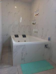 a white bath tub in a bathroom with a green rug at Departamento con jacuzzi 5 piso Condado 2 habitaciones in Quito