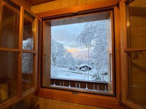 una ventana con vistas a un patio cubierto de nieve en Chalet Specht, gemütliches Ferienchalet auf der Axalp, en Axalp